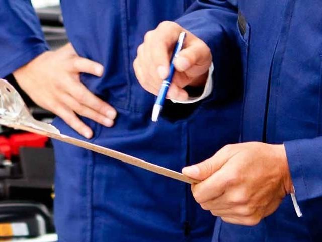 Mechanics doing an MOT test